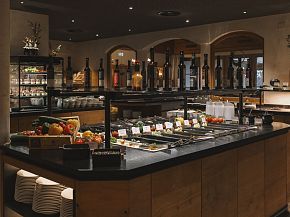 Buffetbereich im Hotel Kaiser Tirol mit verschiedenen Speisen und Getränken. Elegante Präsentation in warmem, einladendem Ambiente.