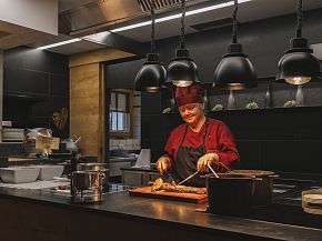 Chef preparing a meal at Hotel Kaiser in Tirol's kitchen.