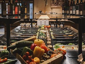 Frisches Gemüse und Weinflaschen an einem Buffet im Hotel Kaiser, Tirol.