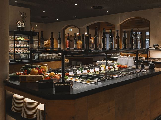Buffetbereich im Hotel Kaiser Tirol mit verschiedenen Speisen und Getränken. Elegante Präsentation in warmem, einladendem Ambiente.